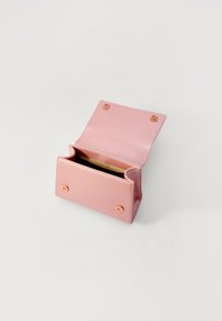 Carteira de couro rosa com um design plano, apresentando um interior dourado e dois fechos de botão circulares. Aberta para revelar compartimentos interiores.