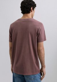 Herre kortærmet t-shirt i dæmpet mauve, lavet af blødt bomuld. Har en rund halsudskæring og en lige pasform, med en glat, mat tekstur.