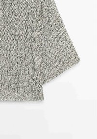 Gray and white knitted fabric with a ribbed hem, showing part of a long sleeve on a white background.