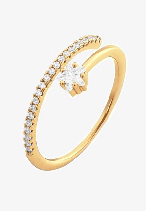 Złoty pierścionek o zakrzywionym kształcie, ozdobiony małymi, przezroczystymi kamieniami po jednej stronie i gwiazdkowym, przezroczystym kamieniem na górze.