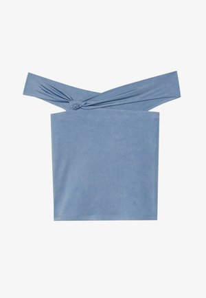 Vaaleansininen olkaimeton paita, joka on valmistettu pehmeästä kankaasta. Paita on varustettu solmittujen hihnojen ja suoraviivaisen leikkauksen kanssa. Pintamateriaali on sileä ilman kuvioita.