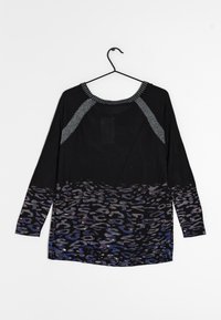 Musta pitkähihainen paita, jossa on hopeakoristeinen kaula-aukko ja harmaan ja sinisen sävyinen gradienttisarvikuosisuunnittelu helman osalta.