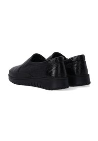 Black slip-on shoes made of textured material with a shiny finish. Features a thick black sole with ridged patterns for grip.