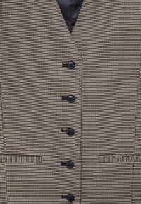 Veste en pied-de-poule marron avec une doublure en satin, comprenant six boutons noirs, deux poches avant, et un col à revers cranté.