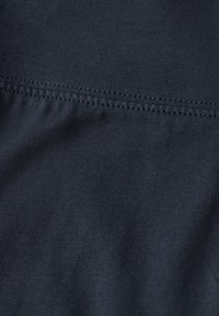 Tummansininen kangas, jossa on sileä pinta, hienojakoista ribbausta ja kontrastiväriä oleva ommel vaakareunassa.