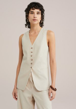 Gilet sans manches beige avec un décolleté en V, doté de six boutons coordonnés et de poches latérales, fabriqué en tissu texturé semblable au lin.