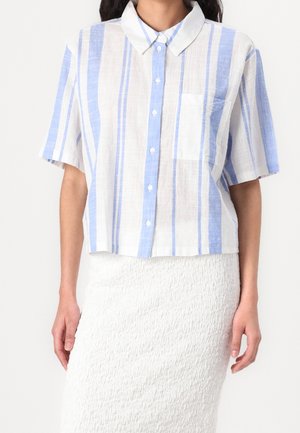 Wit cropped shirt met korte mouwen en blauwe strepen, voorzien van een knoopsluiting aan de voorkant, een kraag en een borstzak. Gemaakt van lichtgewicht stof.