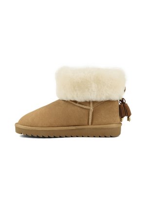 Botte d'hiver en daim beige montant à la cheville, avec une épaisse bordure en fourrure crème et des pampilles marron à l'arrière, dotée d'une semelle plate en caoutchouc.