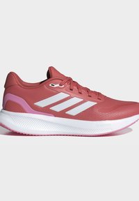 Chaussure de course rouge avec des bandes blanches et une semelle blanche rembourrée étiquetée Cloudfoam, présentée de profil sur un fond uni.