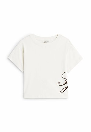 Hvid kortærmet cropped t-shirt lavet af bomuld, med et flydende brunt skrift-design på nederste højre side. Rund halsudskæring.