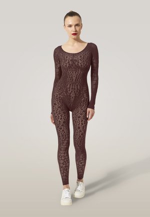 Burgunderfarbener Body mit langen Ärmeln, der ein strukturiertes Spitzenmuster aufweist. Kombiniert mit weißen Sneakers betont das Design eine figurbetonte Silhouette.