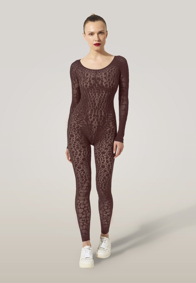 Burgunderfärgad body med långa ärmar, prydd med ett strukturerat spetsmönster. I kombination med vita sneakers förstärker designen en figursydd silhuett.