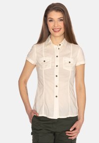 Camicia bianca a maniche corte con chiusura a bottoni, due tasche sul petto e bottoni marroni a contrasto. Tessuto leggero e texture.