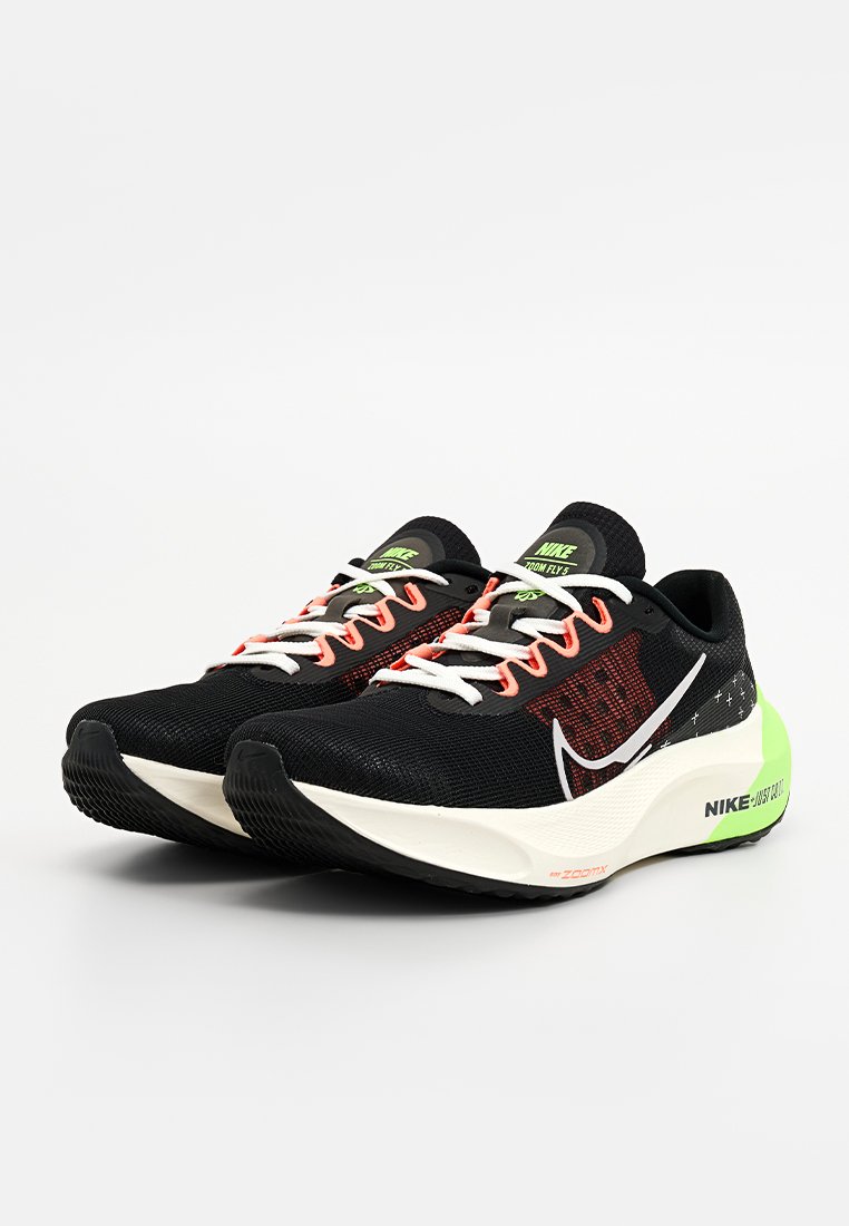 Zapatillas deportivas negras de malla con brillantes acentos en naranja y verde, que presentan un swoosh blanco, suela acolchada y un diseño moderno.