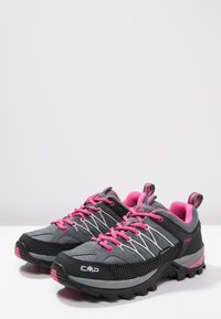 Gray and black hiking shoes with pink accents, featuring a textured upper, reinforced toe cap, and rugged sole for traction.