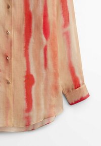Beige Langarmshirt mit rot und pink Aquarellstreifen, mit Knopfleiste und geknöpften Ärmeln, aus leichtem Stoff gefertigt.