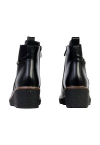 Bottes courtes noires en cuir lisse, talon compensé, avec des accents marron. Dotées d'une fermeture éclair et d'un bouton décoratif sur le côté.