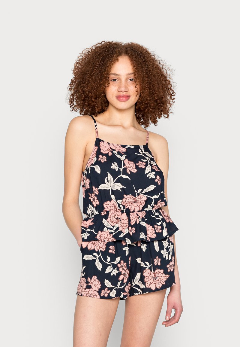 Conjunto de blusa peplum floral e calções em azul marinho com flores cor-de-rosa. Tecido leve, alças finas e um corte descontraído.