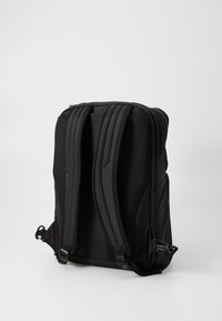 Czarny plecak z wyściełanymi, ergonomicznymi szelkami, siateczkowymi detalami zapewniającymi wentylację oraz smukłym, eleganckim designem. Zamek błyskawiczny w głównym komparcie.