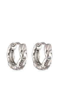 Boucles d'oreilles en forme de cerceau de couleur argentée avec un design texturé et organique. Présente des strass ronds et transparents incrustés sur le devant.