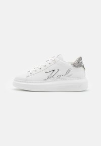 Hvit sneakers med en glatt skinnoverdel, sølv "Karl"-logo, og en teksturert metallisk sølvaccent ved hælen. Tykk gummisåle.