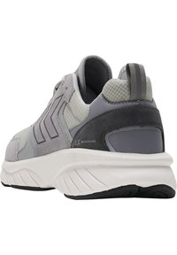 Grå sportskor med en kombination av mocka och meshöverdel, en vadderad vit mellansula, texturerad svart yttersula och stickade detaljer.