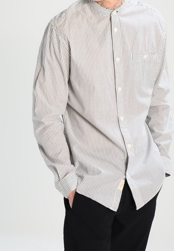 Camicia a maniche lunghe a righe con colletto alla coreana, righe verticali grigio chiaro e blu scuro, e taschino sul petto con chiusura a bottone.