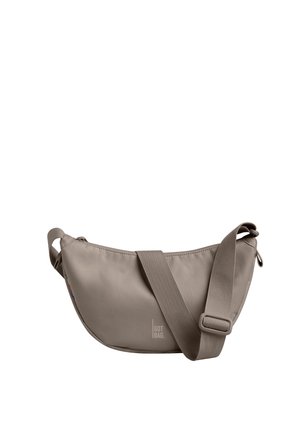 Torebka na ramię w kształcie półksiężyca w kolorze taupe z regulowanym szerokim paskiem i logo "GOT BAG" na środku z przodu.