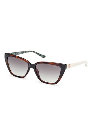 Occhiali da sole cat-eye con montatura in tartaruga e lenti sfumate. Tempi off-white con dettagli del logo e un motivo geometrico verde all'interno.