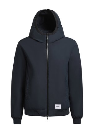 Chaqueta acolchada azul marino con capucha, cierre frontal de cremallera, puños y dobladillo de canalé. Presenta un parche con el logo en el lado izquierdo. Material suave y ligero.