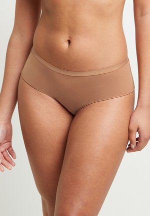 Bikini hipster beige realizzati in tessuto morbido, con un design senza cuciture, cinturino confortevole e uno stile minimalista.