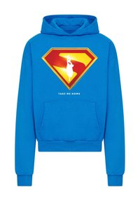 Modrá mikina s kapucňou s veľkým červeným a žltým logom Supermana, pod ktorým je biely silueta a text "VZLAĎ MA DOMOV". Materiál: bavlna, predná vrecko.
