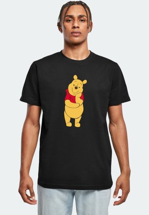 Black t-shirt featuring a yellow cartoon bear with a red shirt graphic in the center. Short sleeves, standard crew neck design.