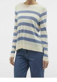 Pull rayé crème et bleu clair, manches longues, col rond, tissu en maille douce, coupe droite, fentes latérales à l'ourlet, porté avec un jean bleu.