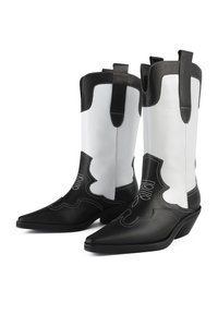 Cizme de cowboy din piele alb-negru cu vârfuri ascuțite, cusături decorative și tălpi înalte. Caracteristici ale texturilor contrastante și mânere de tragere.