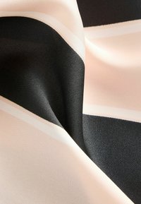 Gestreifter Stoff mit weicher Textur, der abwechselnd schwarze und blassrosa Bänder zeigt, akzentuiert durch schmale weiße Streifen.