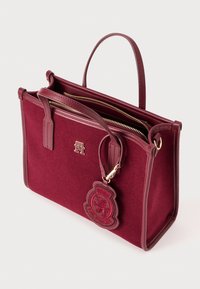 Burgunderfarbige Filztasche mit Lederakzenten, doppelt gefütterten Reißverschlusstaschen und einem Logo-Anhänger. Verfügt über einen kurzen Griff und ein strukturiertes Design.