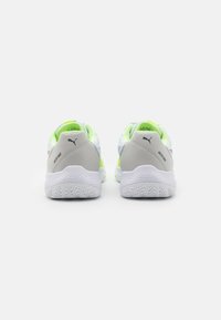 Zapatillas deportivas en gris y blanco con acentos en verde neón, parte superior de malla texturizada y suela de goma con un patrón de goma en zigzag.