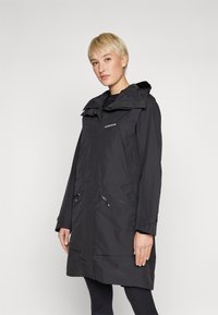 Svart vanntett frakk med hette, to frontlommer med glidelås, og kne-lengde design. Minimalistisk stil med en jevn tekstur.