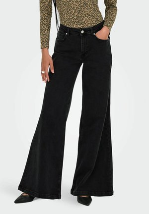 Black wide-leg jeans made from denim, featuring a high waist, front pockets, and a clean finish. Paired with a leopard print top.