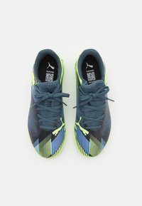 Scarpe sportive con tomaia in rete caratterizzata da strisce diagonali blu e verdi, dettagli neri e lacci grigi. Suola testurizzata e logo.