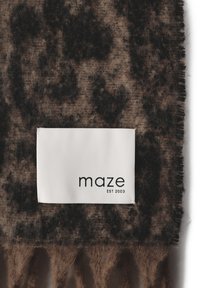 Braun-schwarzer Schal mit Muster und ausgefransten Rändern. Der Stoff wirkt weich und strukturiert. Das Etikett trägt die Aufschrift "maze EST 2003" in Schwarz.