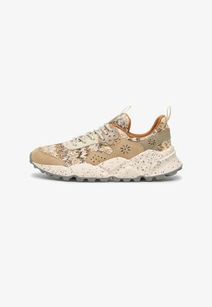 Low-top multicolor beige sneaker with speckled chunky sole, woven fabric upper, suede overlays, and lace-up closure, shown in side profile.