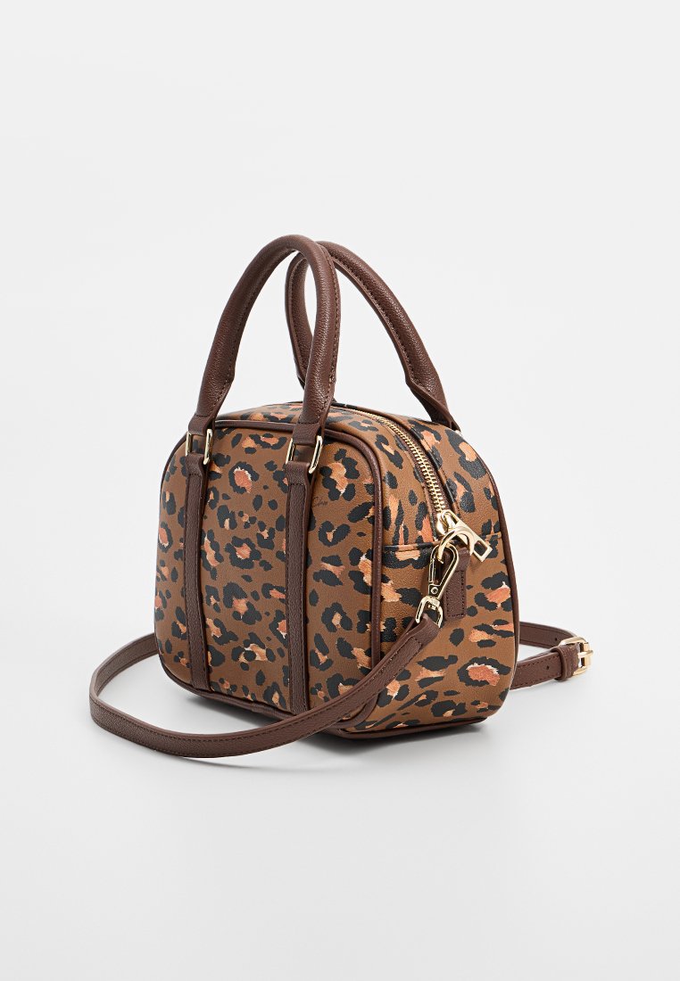 Torebka w leoparda wykonana z brązowego materiału syntetycznego, z złotymi akcentami, podwójnymi uchwytami u góry i regulowanym paskiem na ramię. Kompaktowy, pudełkowaty kształt.
