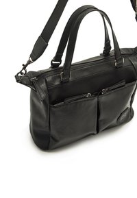 Bolso de mano de cuero negro con dos bolsillos frontales con cremallera, acabado texturizado, asas resistentes y una correa de hombro desmontable. Cuenta con un acento de logo.