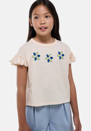 T-shirt en coton pêche avec des manches courtes volantes, orné de trois fleurs brodées en bleu et vert sur le devant.