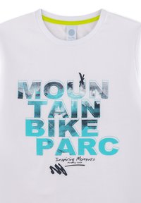 Weißes T-Shirt mit Rundhalsausschnitt, mit auffälligem blauen und schwarzen grafischen Text, der "MOUNTAIN BIKE PARC" und "Inspiring Moments" liest.