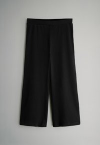 Schwarze, weite Hosen mit geripptem Textur und elastischem Bund. Der Stoff ist glatt und leicht, ideal für die Freizeit.