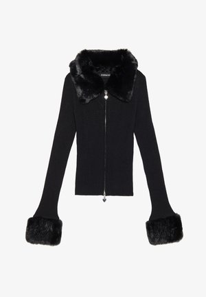 Chaqueta de punto negra acanalada con cuello y puños de piel sintética. Presenta una cremallera plateada y un tirador en forma de corazón. Diseño entallado.