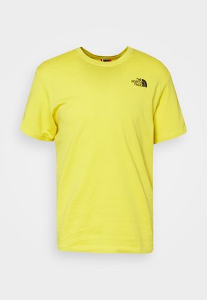 Gul bomullst-shirt med korta ärmar och rund halsringning, med en liten svart logotyp på övre vänstra bröstet. Slät textur, avslappnad passform.